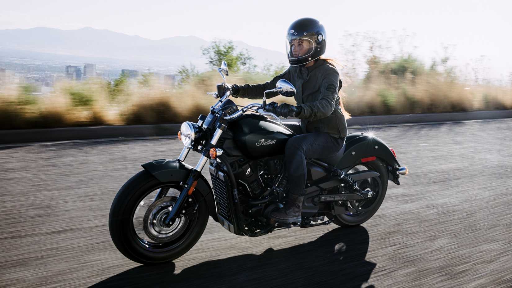 2026 Indian Scout Sixty Classic accelerating on a winding road front third quarter view