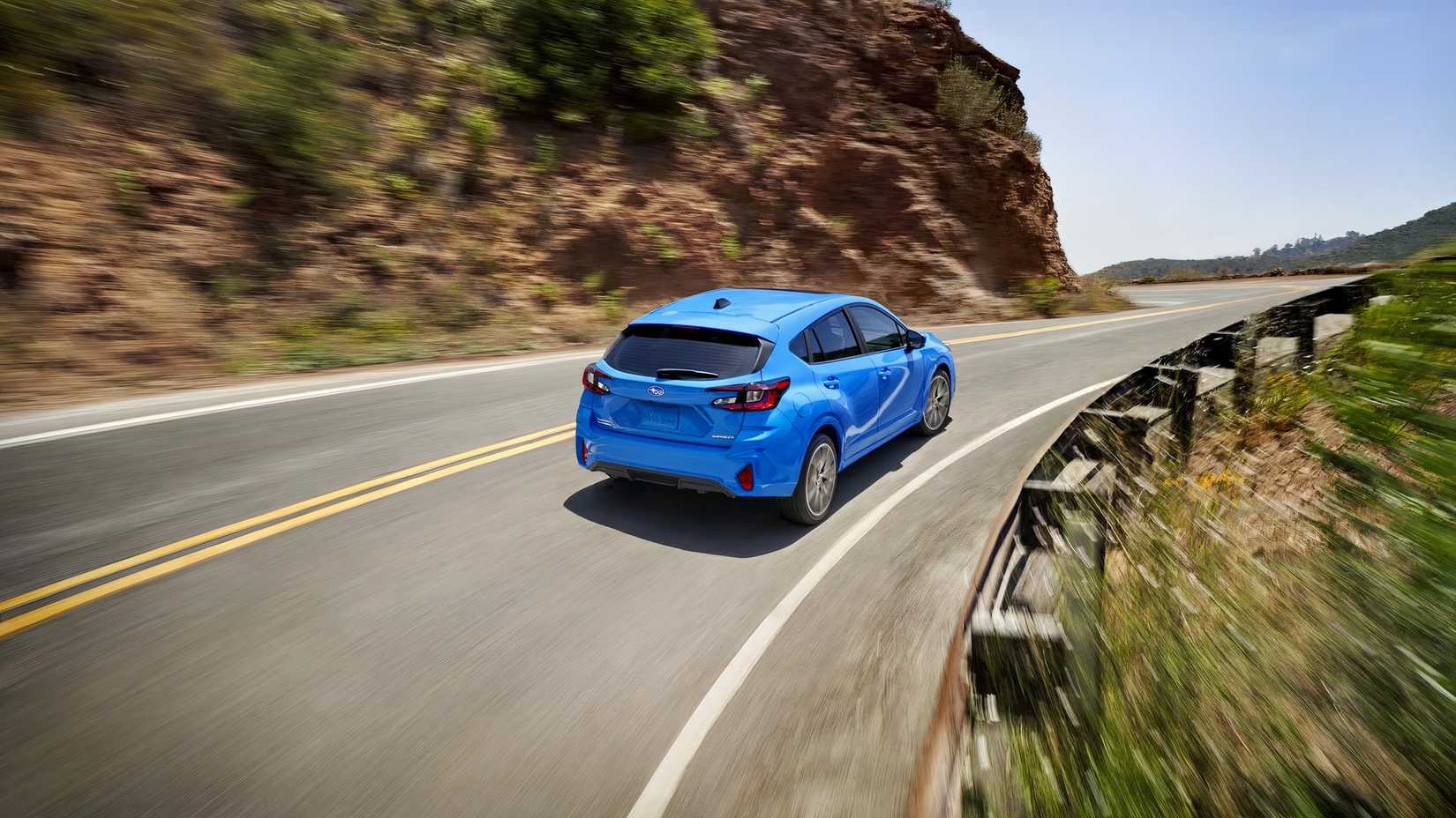 Foto traseira de um Subaru Impreza Hatchback 2026 dirigindo em uma estrada