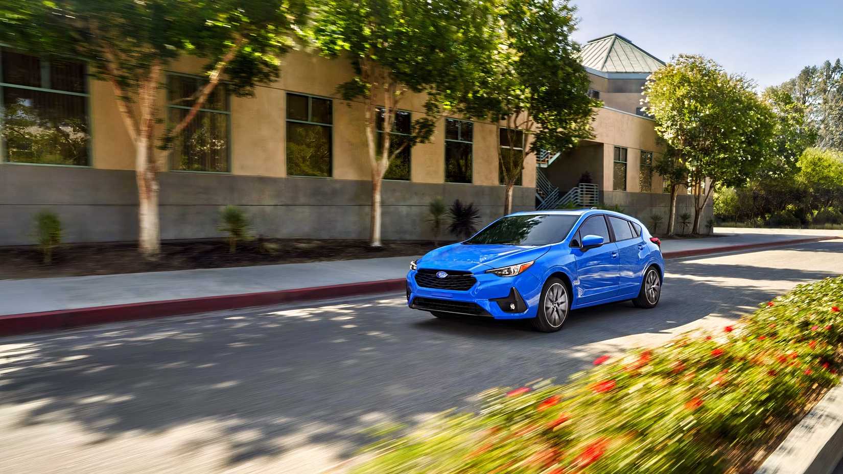 Front shot of a blue 2026 Subaru Impreza Hatchback driving on the road