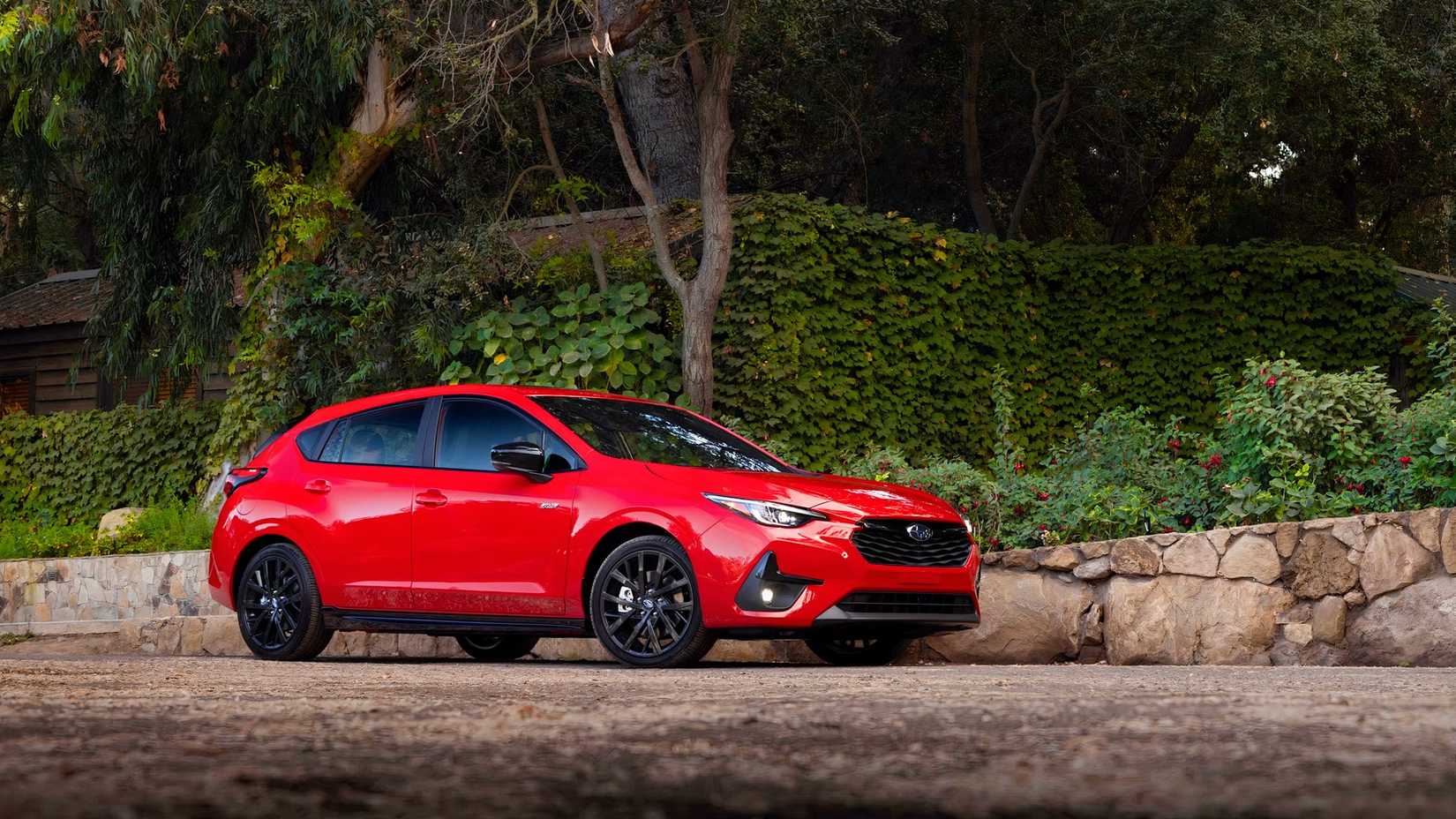 Foto frontal 3/4 de um Subaru Impreza Hatchback 2026 vermelho estacionado