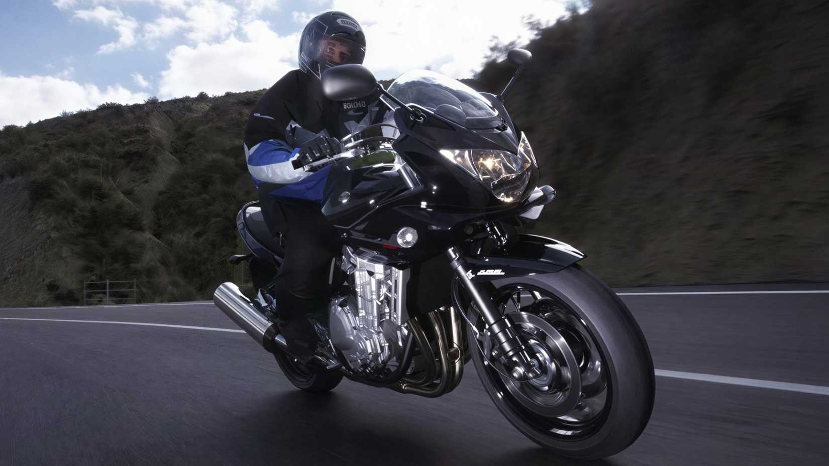 Rider on a 2011 Suzuki Bandit 1250S in black cornering, front third quarter view