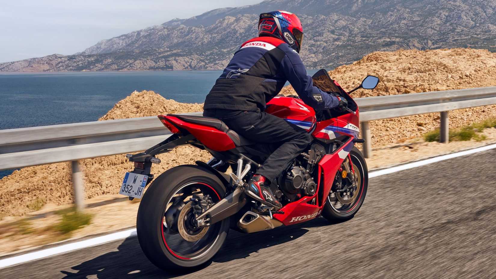 2026 Honda CBR650R cruzando na rodovia, vista traseira do terceiro quarto