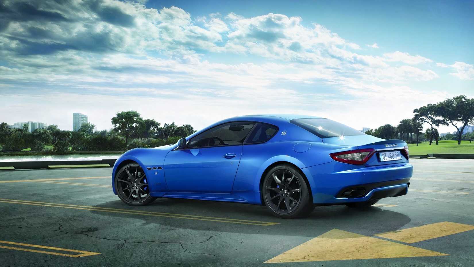 Foto traseira 3/4 de um Maserati GranTurismo de primeira geração estacionado em uma plataforma