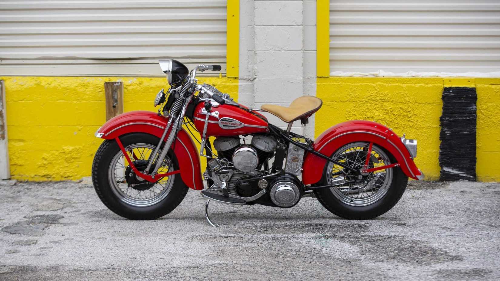 A civilian-spec 1942 Harley-Davidson WLA in red parked on the side of the road, side profile static view