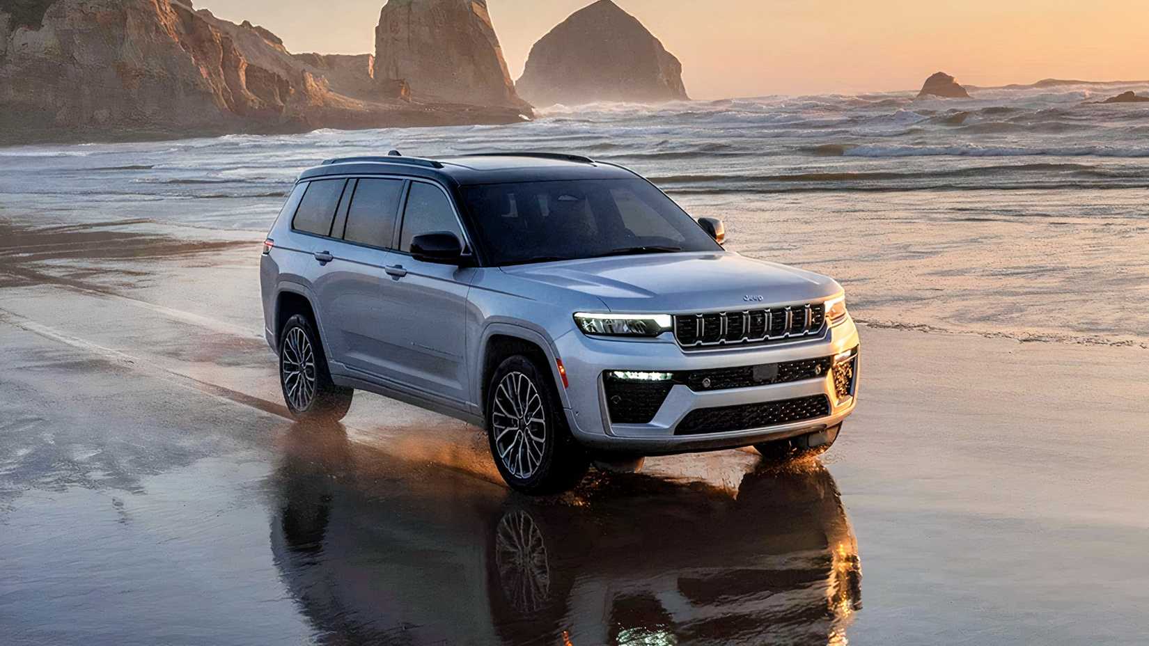 A Jeep Grand Cherokee L drives on the beach