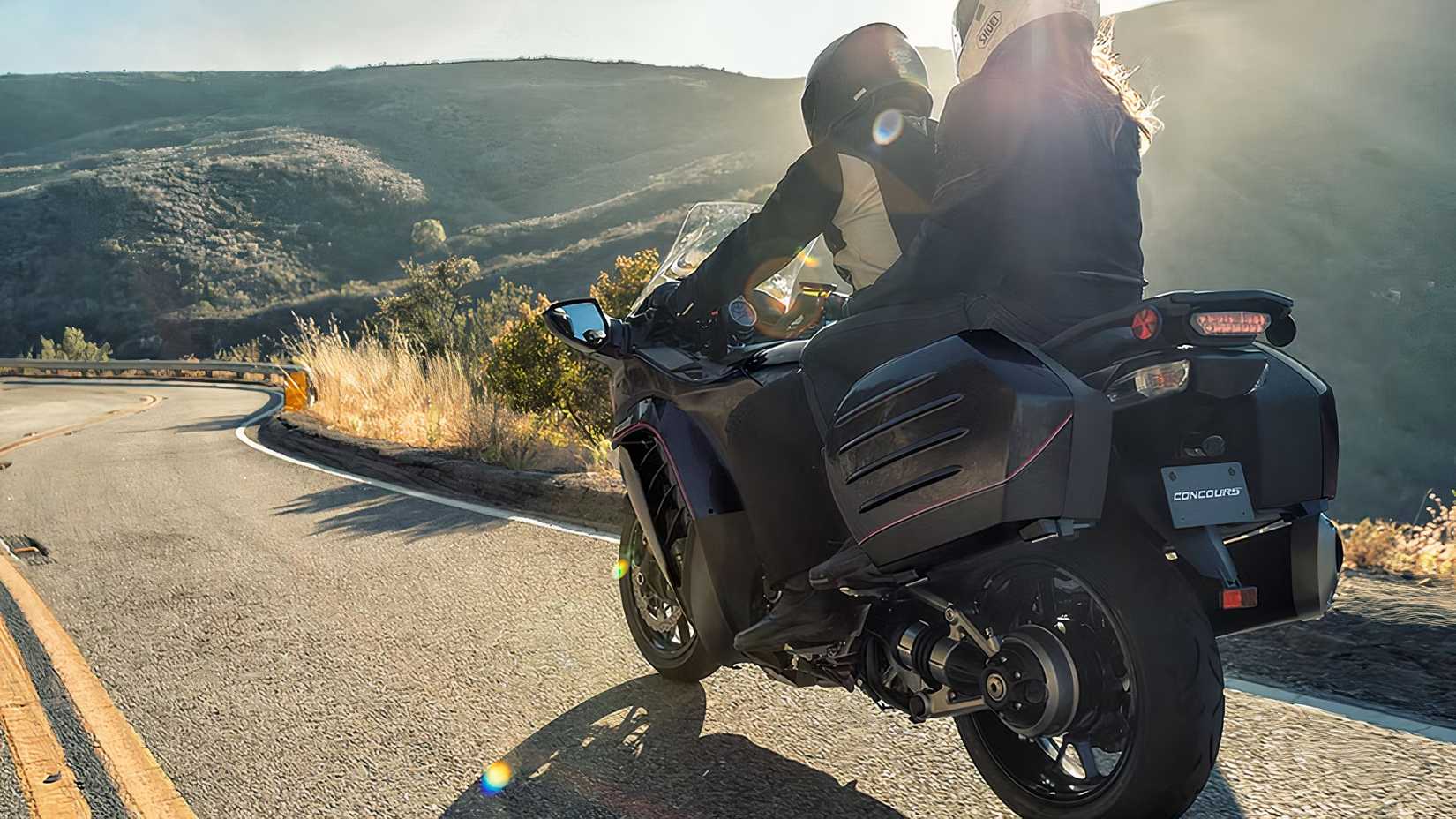 Foto traseira do Kawasaki Concours 14 com piloto e passageiro descendo uma estrada sinuosa na montanha