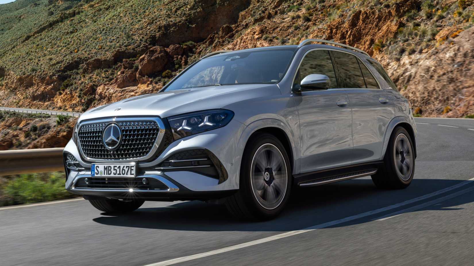 2027 Mercedes-Benz GLE Class accelerating through a winding mountain road front third quarter view