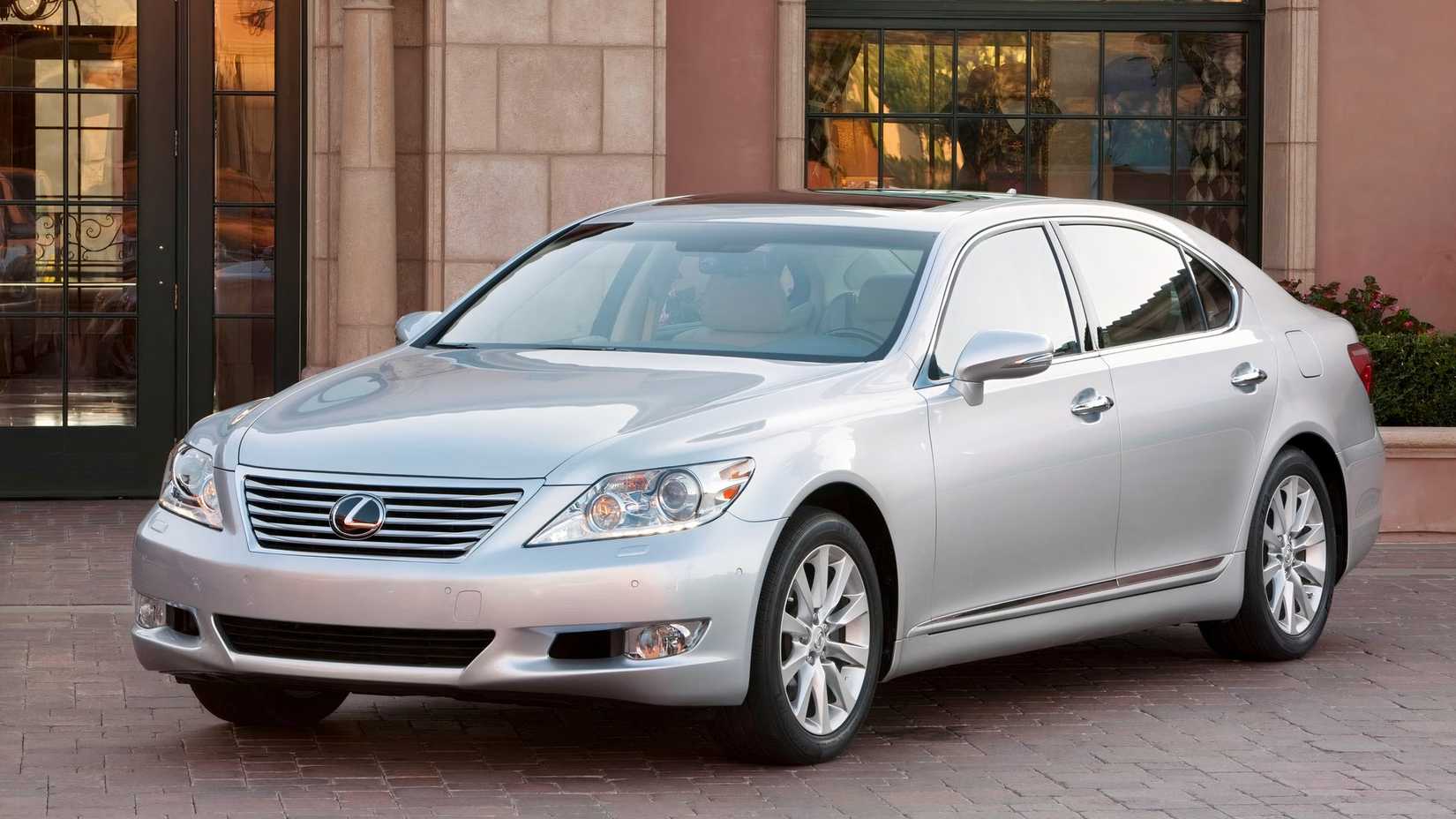 Foto frontal 3/4 de um Lexus LS 2012 estacionado em frente à casa