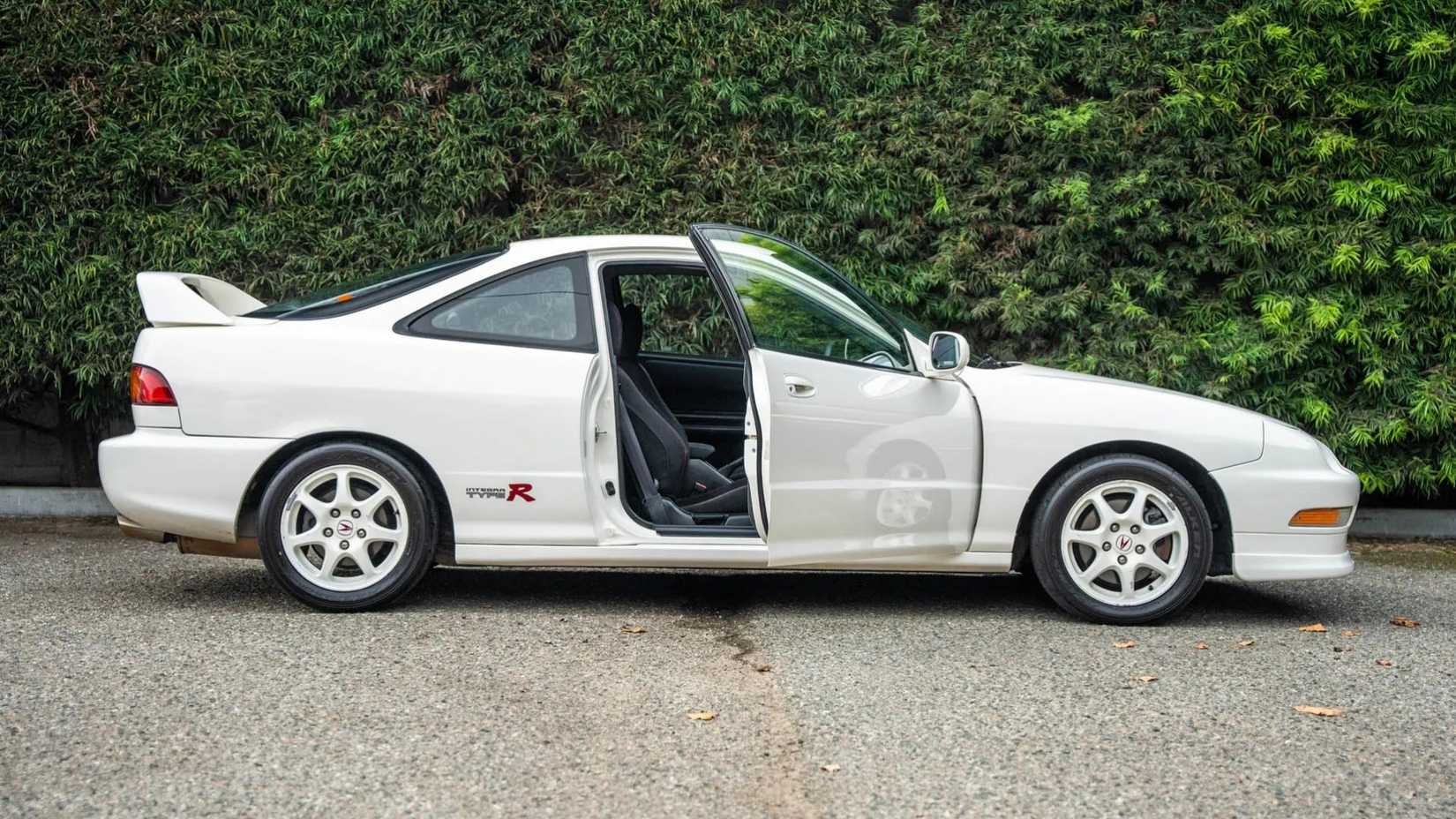 Foto lateral de um Acura Integra Type R 1997 com portas abertas estacionado em um estacionamento