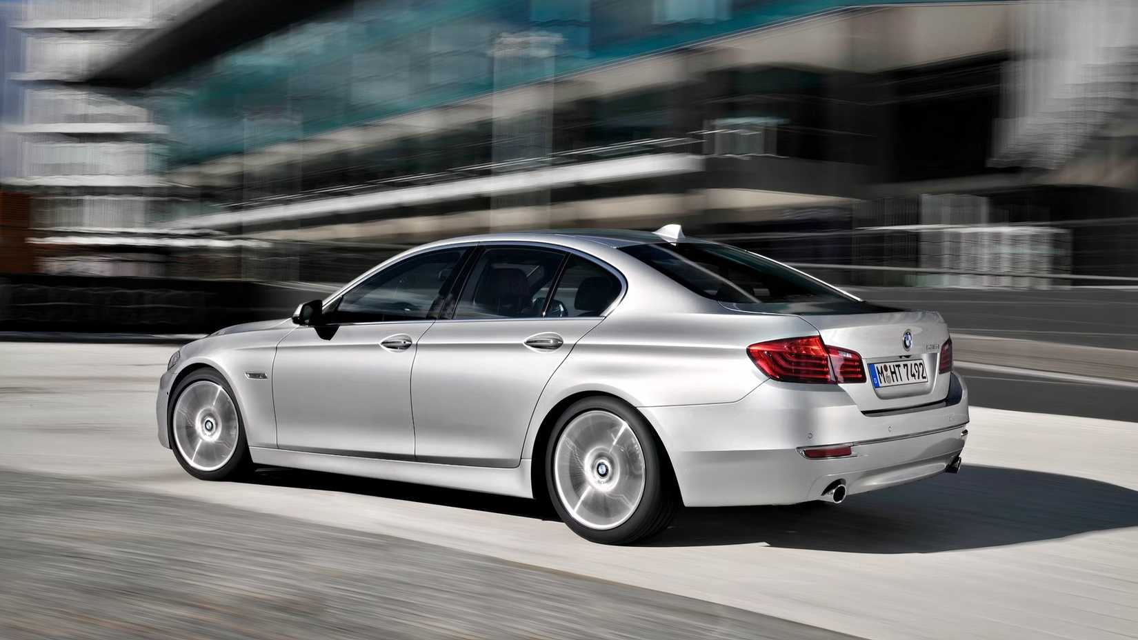 Foto traseira 3/4 de um BMW Série 5 2016 prateado acelerando