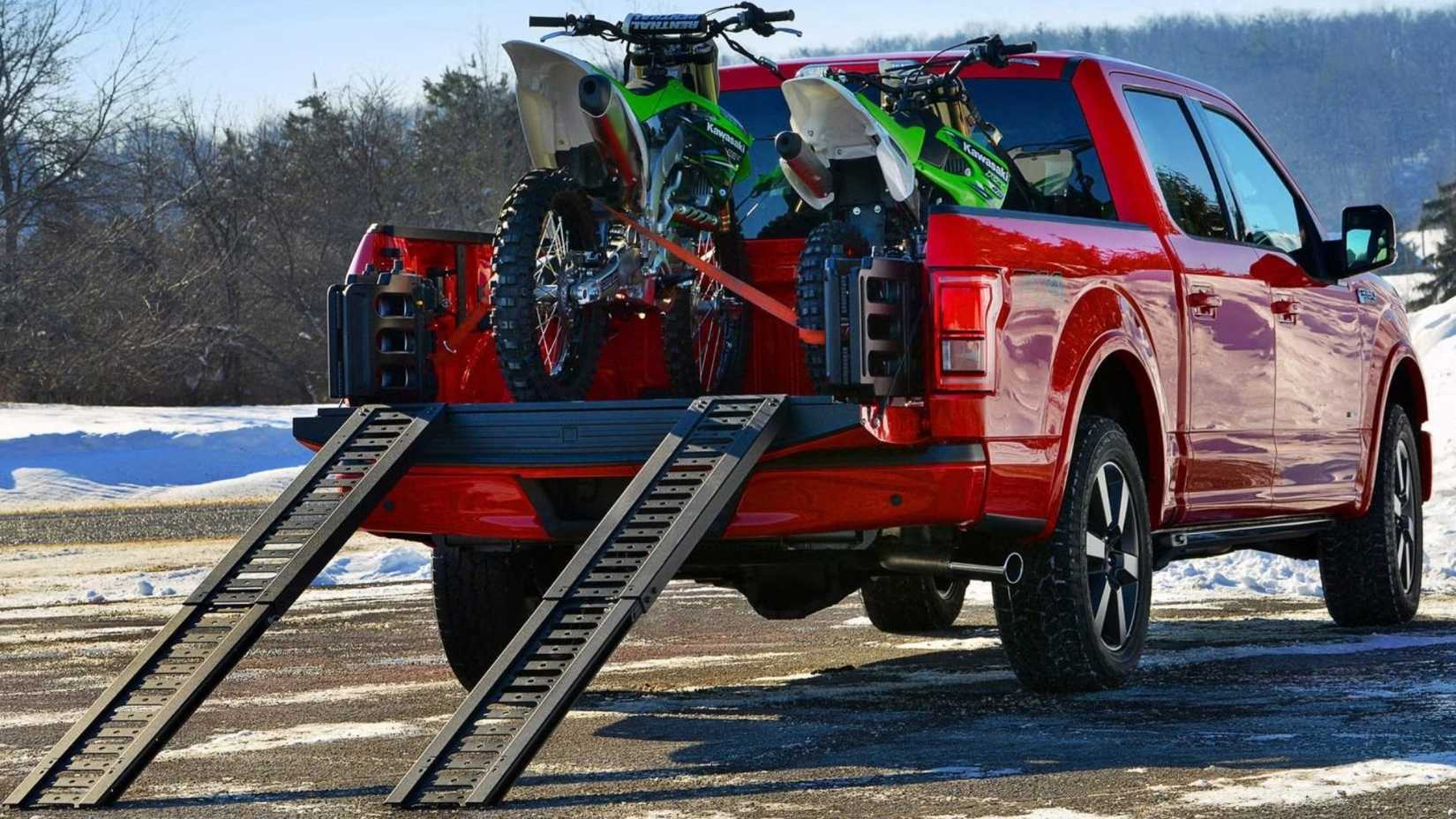 Foto traseira 3/4 de um Ford F-150 2017 com motos sujas na caçamba