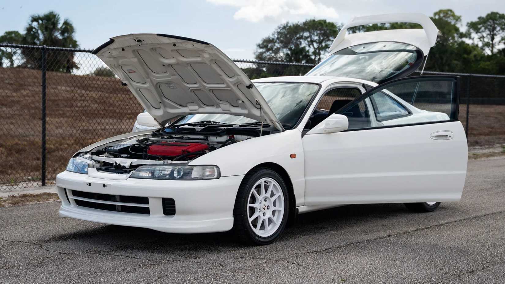 Foto frontal 3/4 de um Acura Integra Type R 1999 com portas, capô e porta-malas abertos