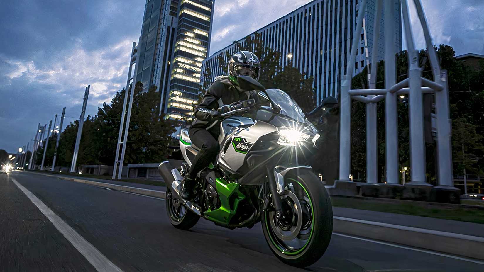 Front shot of a 2024 Kawasaki Ninja 7 Hybrid riding through city at night