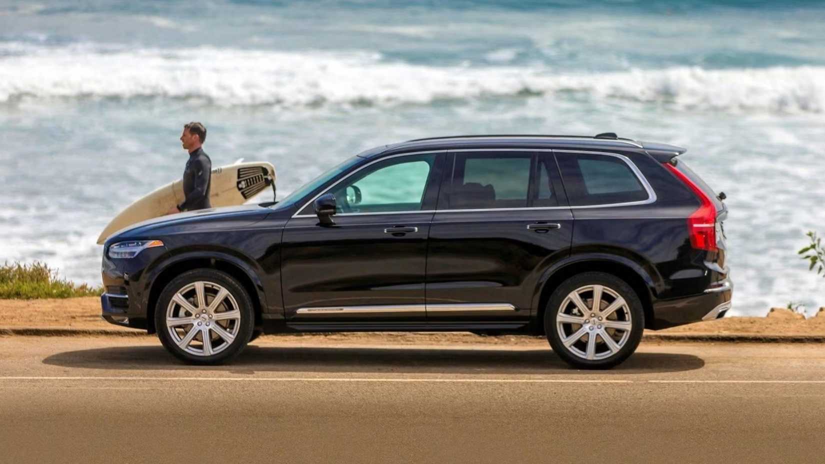 Side shot of a 2018 Volvo XC90 with surfer walking beside