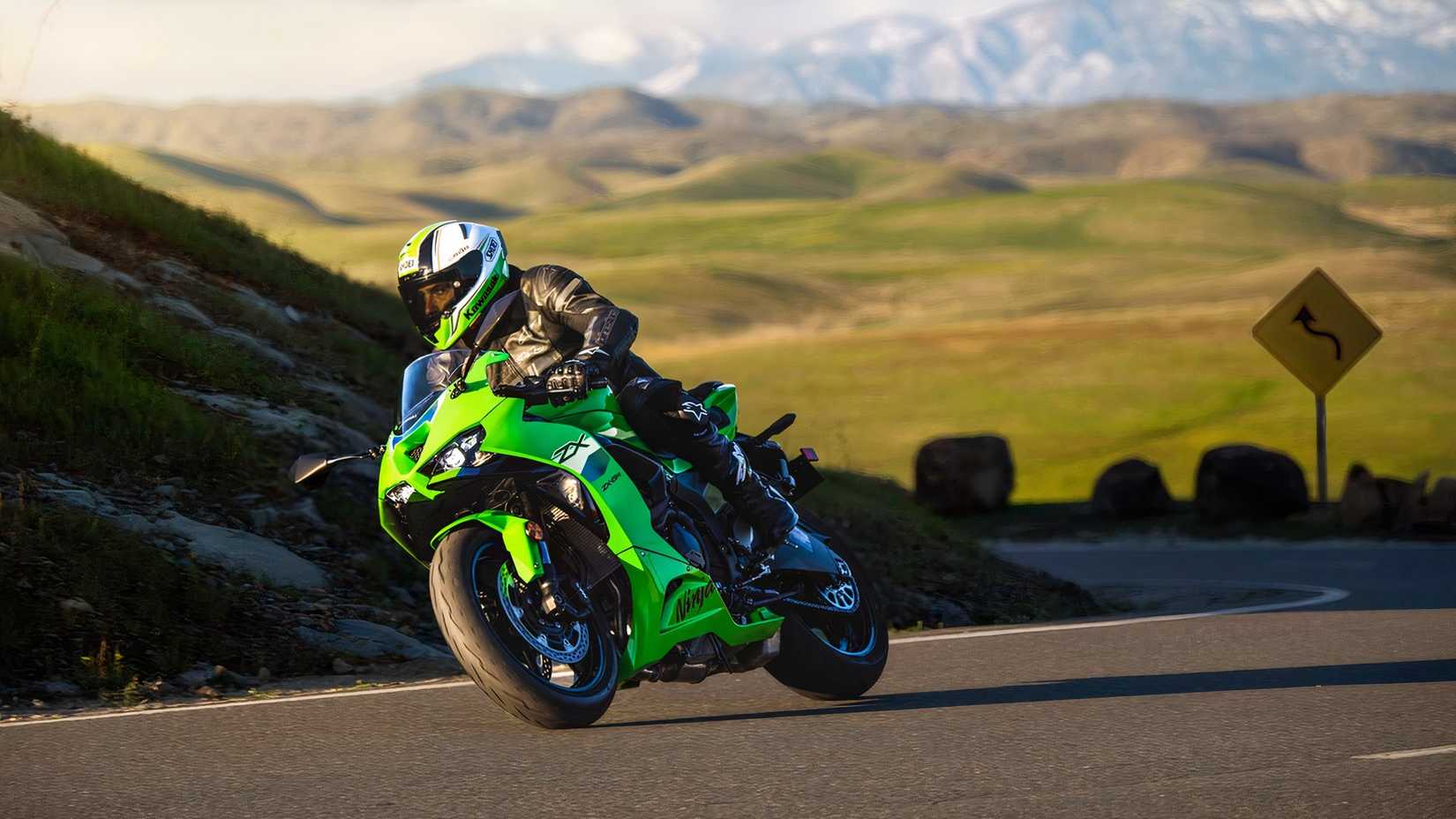 Foto frontal de uma Kawasaki Ninja ZX-6R 2026 dirigindo em uma rodovia rural