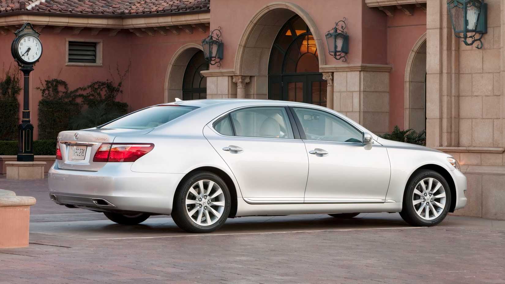 Foto traseira 3/4 de um Lexus LS 2012 estacionado em frente à casa