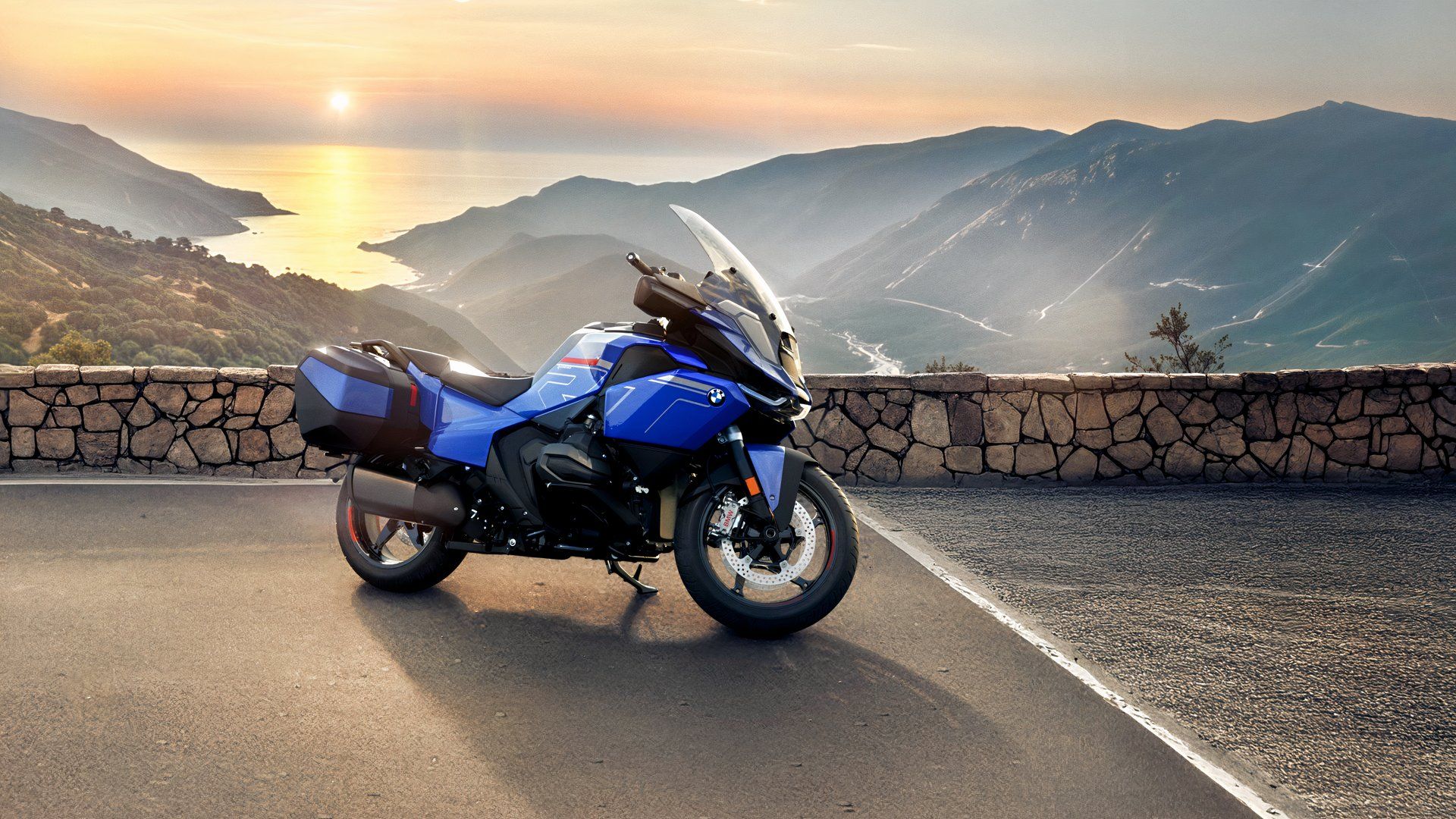 Fotografia lateral de uma BMW R 1300 RT 2026 estacionada em um terreno com vista para um vale que se abre para o oceano