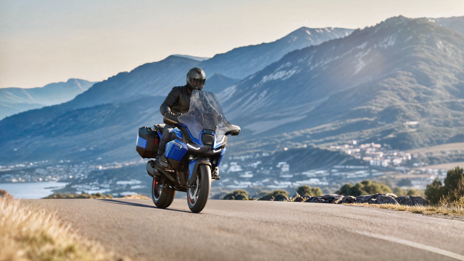 Front shot of the 2026 BMW R 1300 RT driving in front of a mountain range