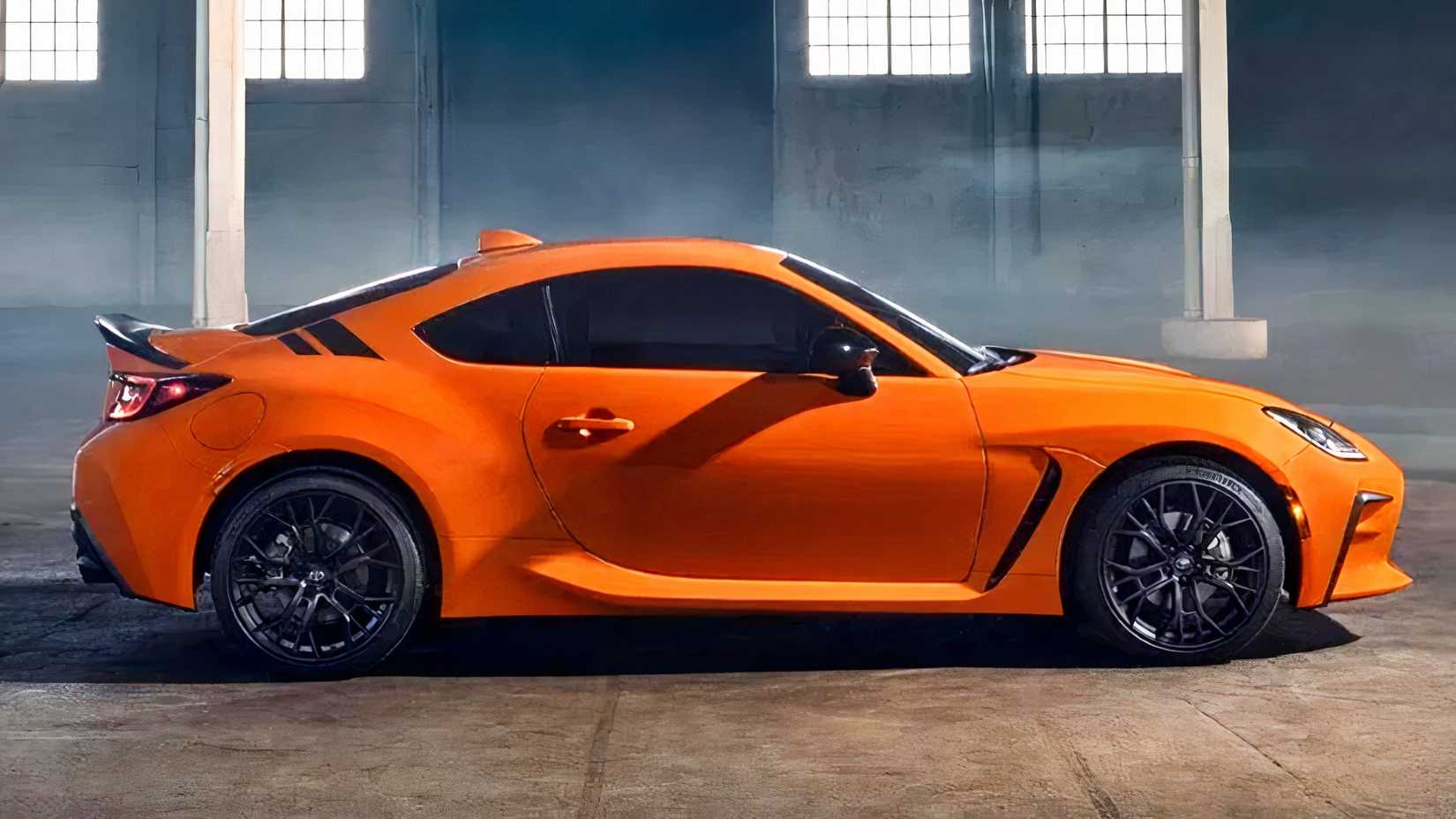 Side shot of an orange Toyota GR86 parked in warehouse