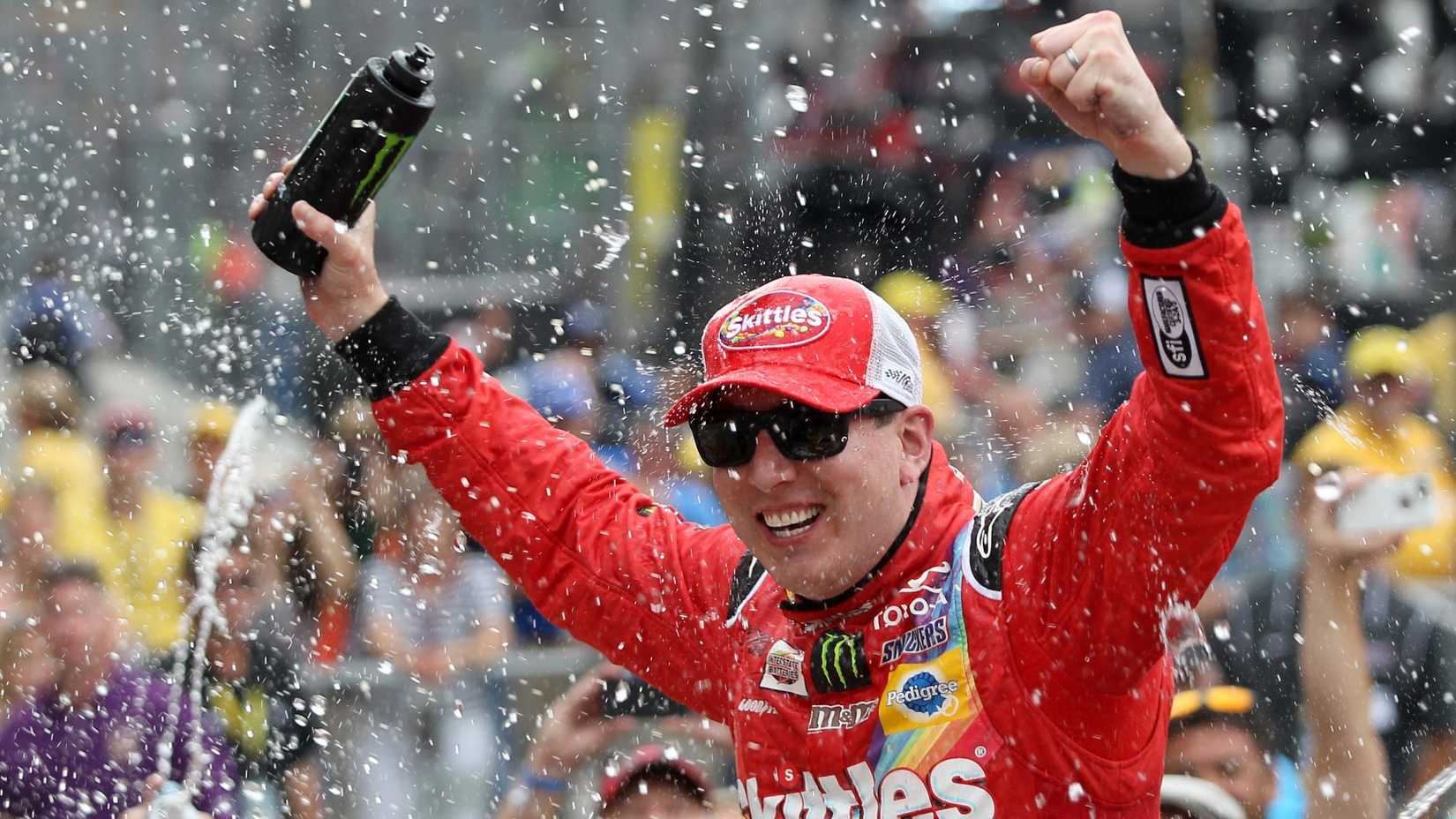 Kyle Busch, piloto do Skittles Toyota nº 18, comemora em Victory Lane após vencer a NASCAR Sprint Cup Series Crown Royal apresenta o Jeff Kyle 400 no Brickyard em Indianapolis Motor Speedway em 26 de julho de 2015 em Indianápolis, Indiana.
