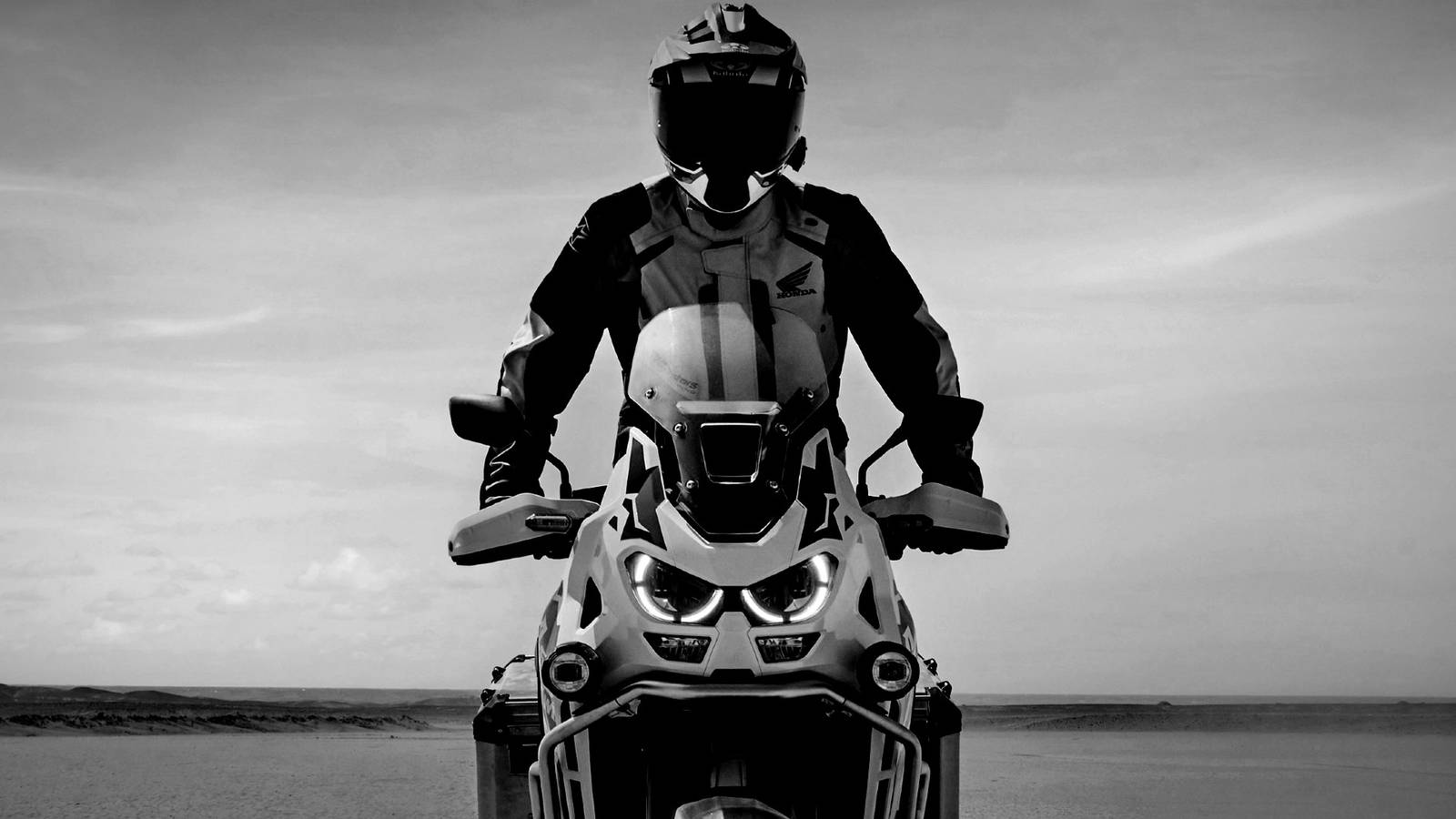 Una moto Honda Africa Twin in movimento su terreni accidentati, con un motore robusto e una sospensione adatta a lunghe distanze