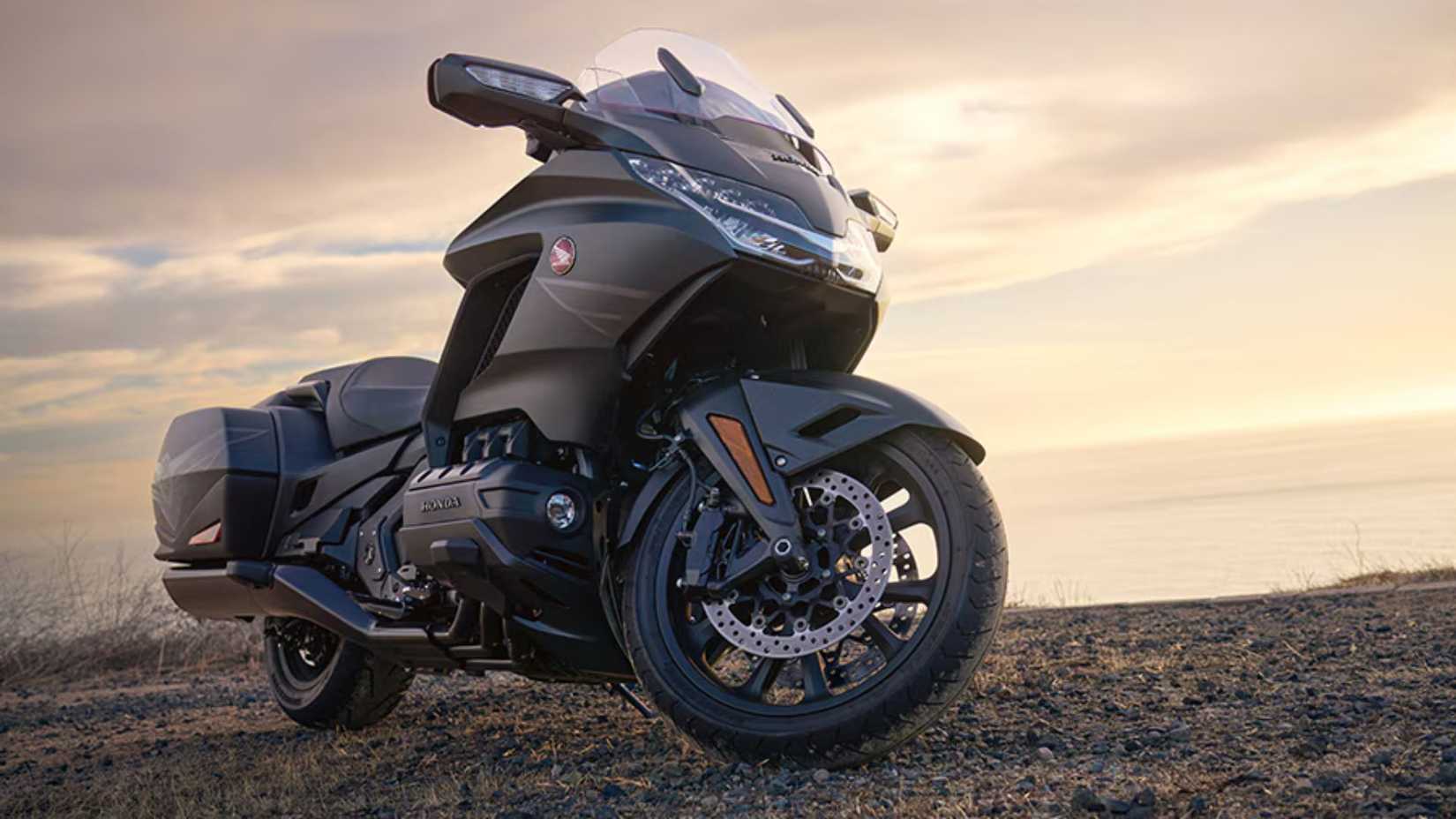 Foto estática frontal de baixo perfil do 2026 Honda Gold Wing ao ar livre.