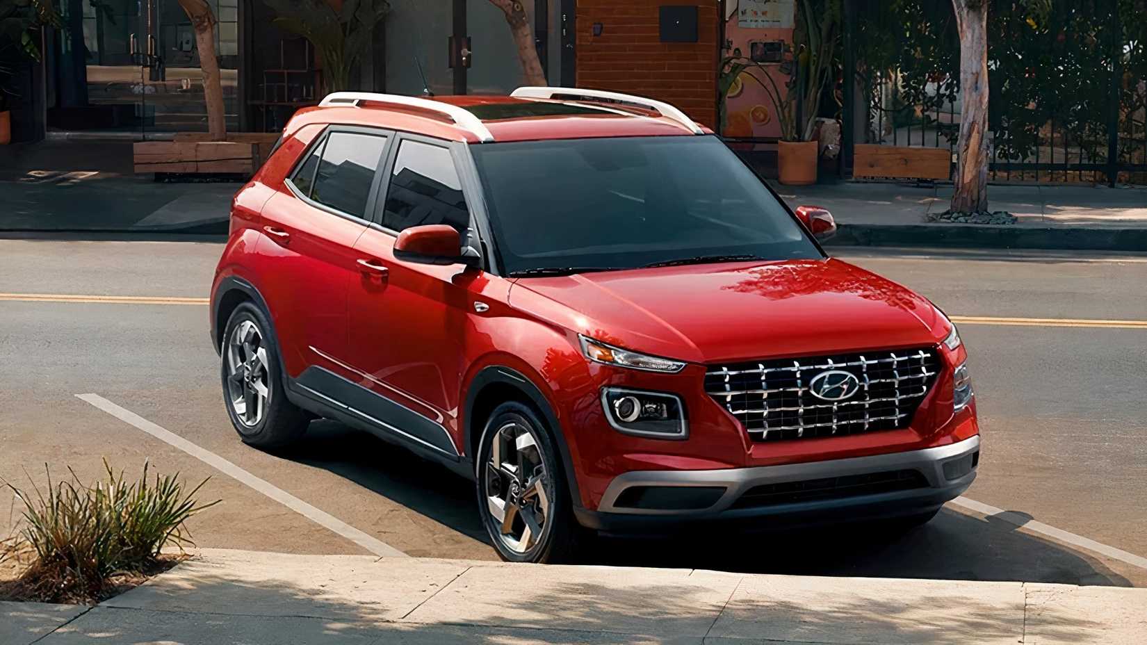 Uma foto frontal 3/4 de um Hyundai Venue 2026 vermelho em uma vaga de estacionamento
