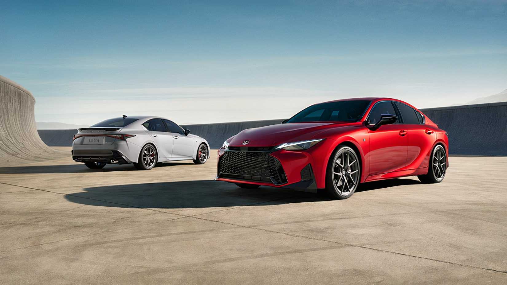 Two 2026 Lexus IS 350 models parked in a scenic location