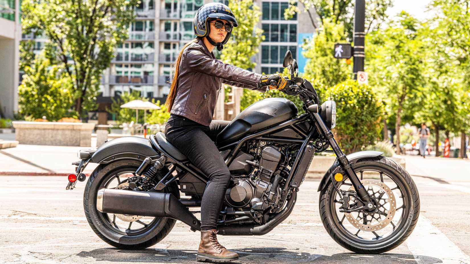 Um piloto baixo sentado na foto cinematográfica de perfil lateral da Honda Rebel 1100