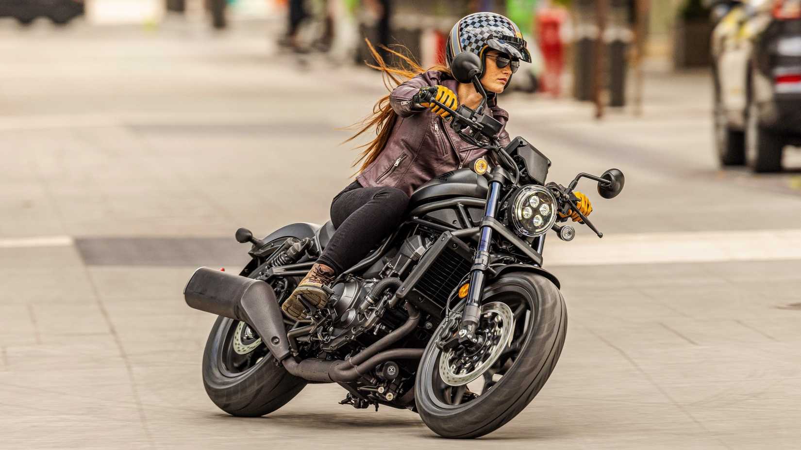 Honda Rebel 1100 curvando ao longo de uma estrada urbana vista do terceiro quarto