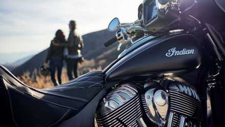 Foto artística do tanque, assento e motor Indian Roadmaster com piloto e garupa admirando a vista ao fundo