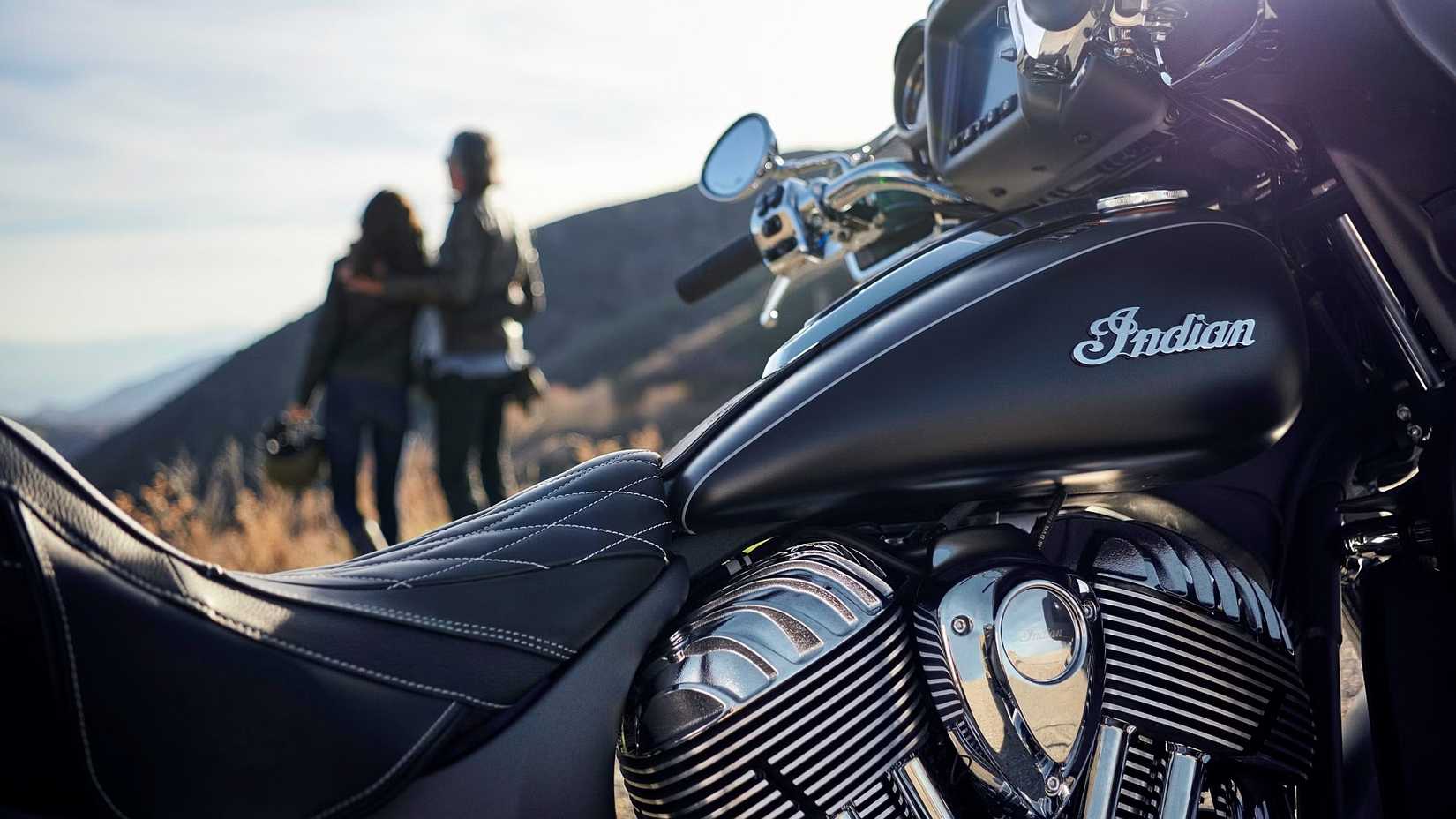 Foto artística do tanque, assento e motor Indian Roadmaster com piloto e garupa admirando a vista ao fundo