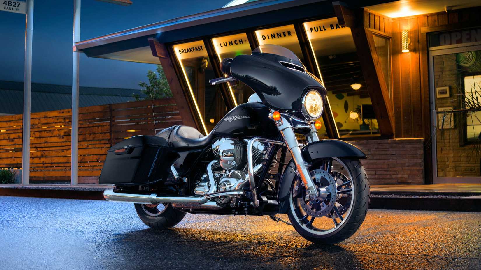 Black 2016 Harley-Davidson Street Glide estacionada em frente a um café