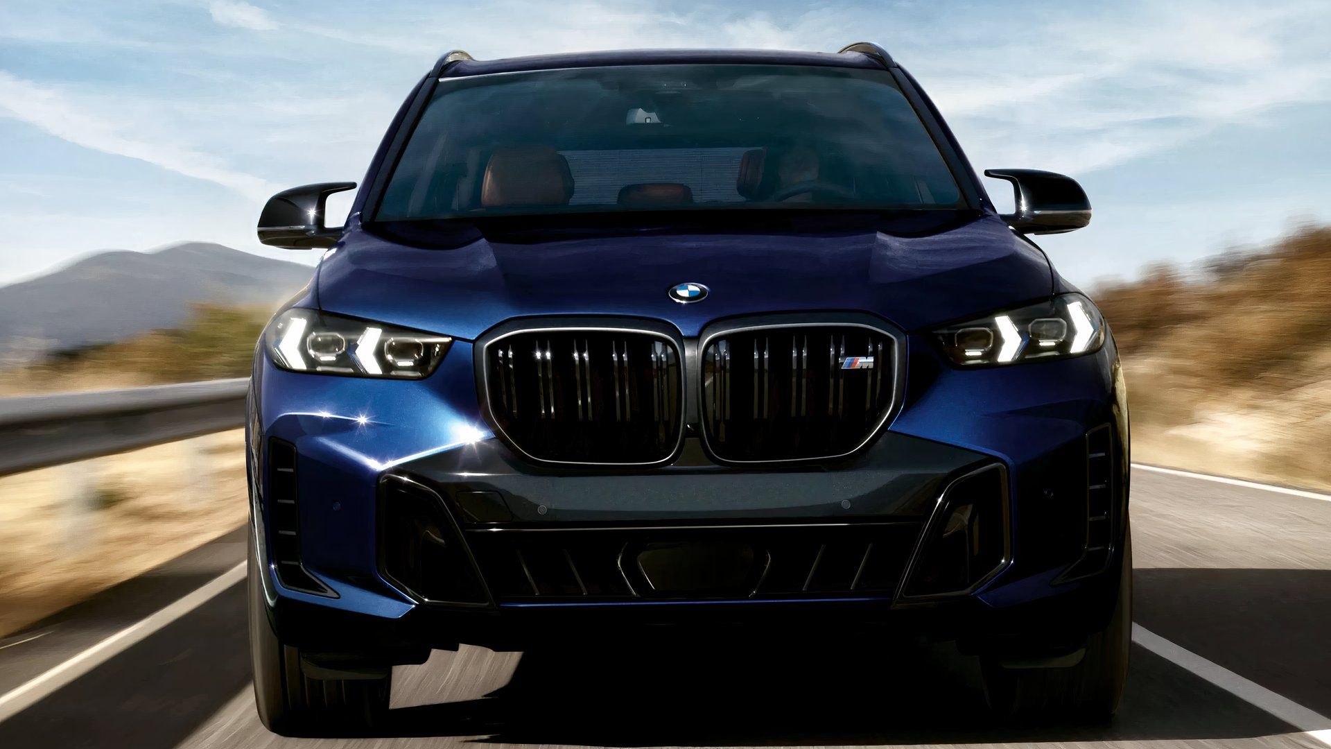 Foto frontal do BMW X5 M 2026 dirigindo na estrada