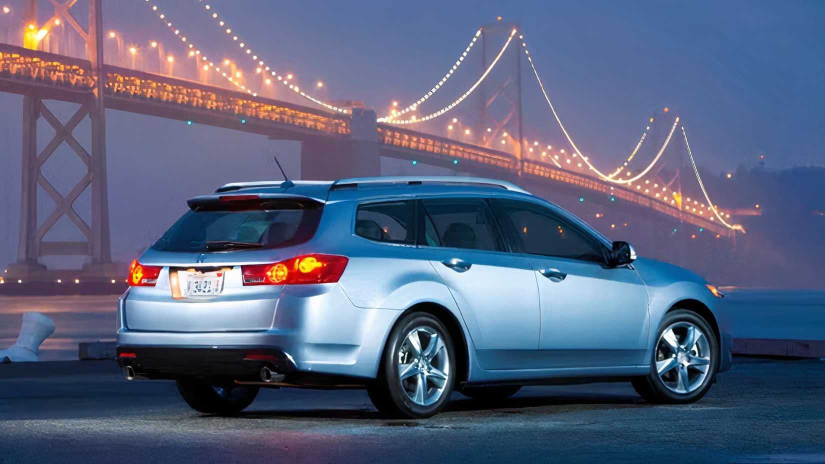 Rear 3/4 shot of 2014 Acura TSX Sport Wagon parked in front of bridge at night