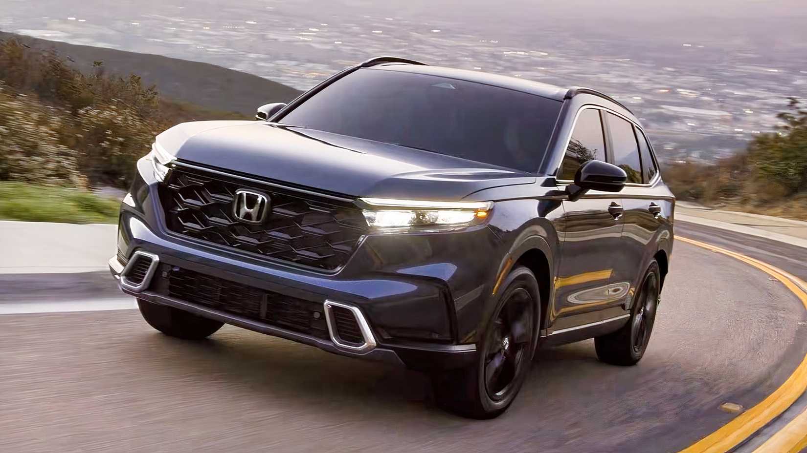 Front 3/4 action shot of 2026 Honda CR-V Sport Touring Hybrid driving on road