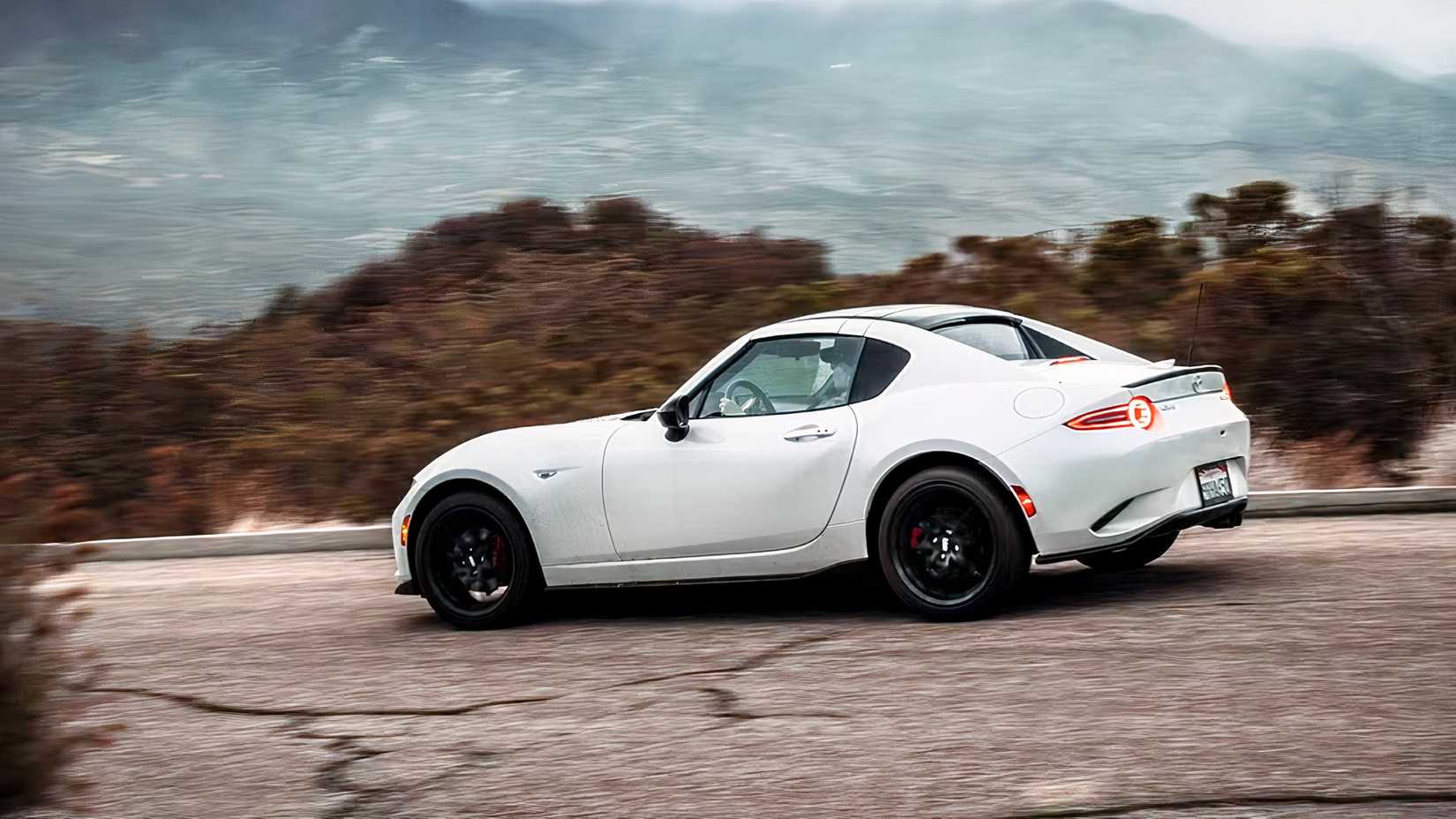 Foto de ação 3/4 traseira do Mazda MX-5 Miata RF 2026 dirigindo