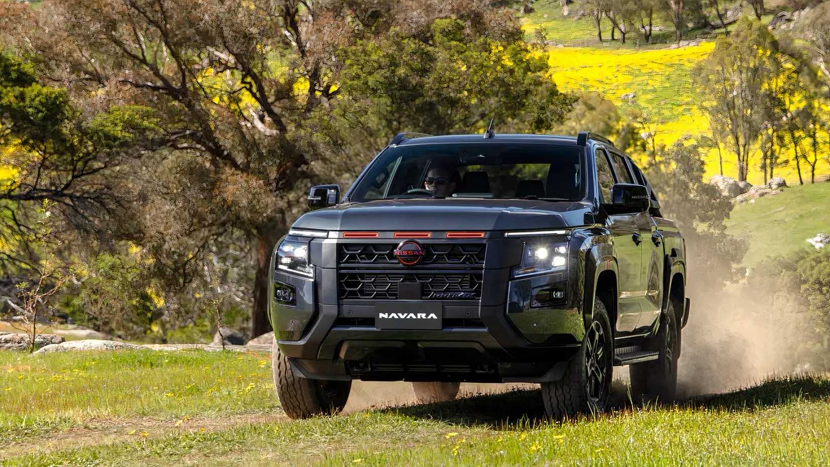 Front 3/4 action shot of 2026 Nissan Navara driving in field