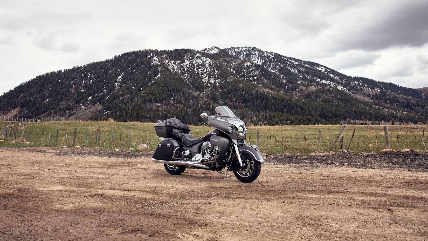 Indian Roadmaster em um estacionamento de terra com uma montanha coberta de neve ao fundo