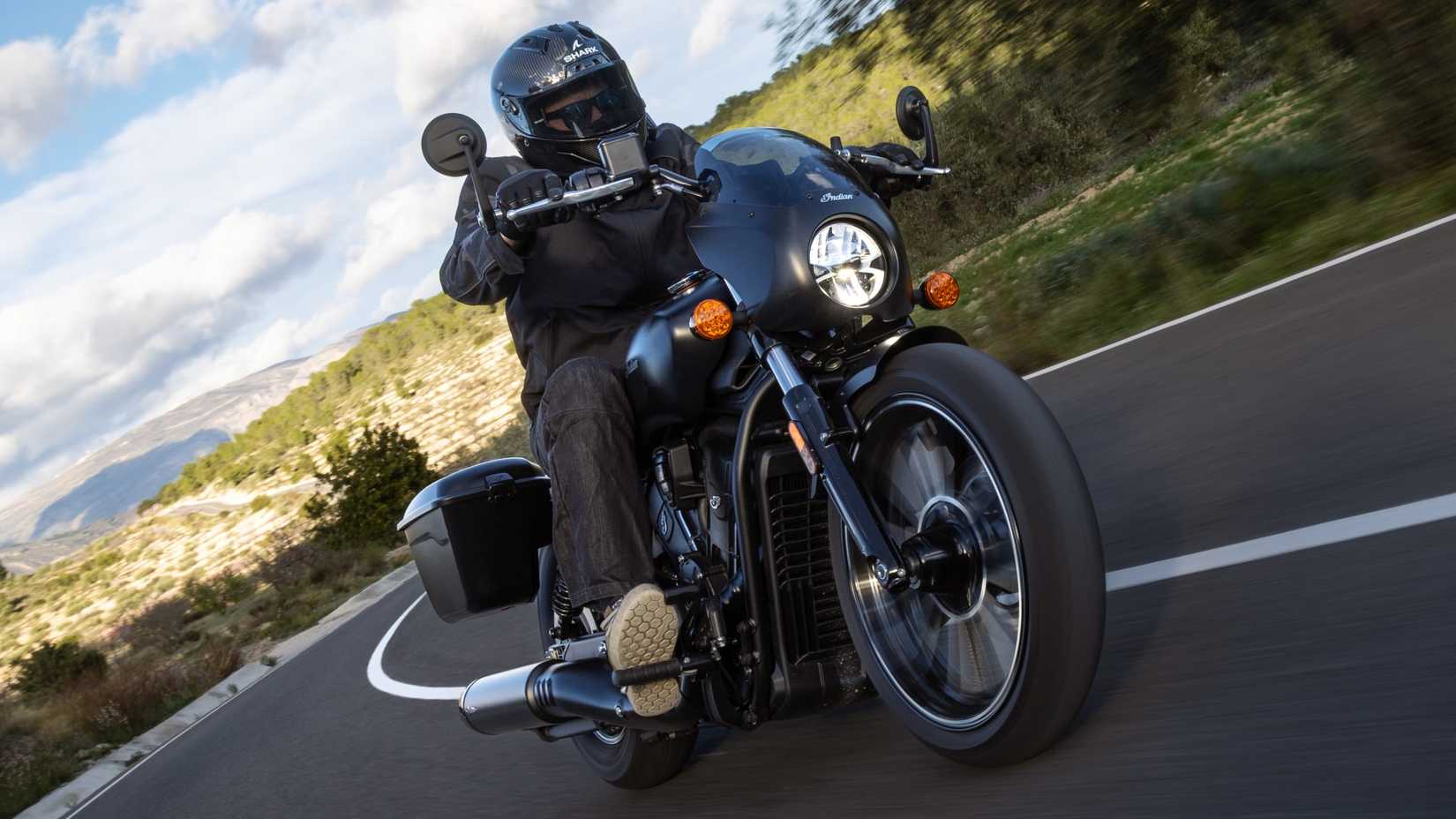 2026 Indian Sport Scout RT em curvas pretas ao longo de uma estrada sinuosa vista frontal do terceiro quarto
