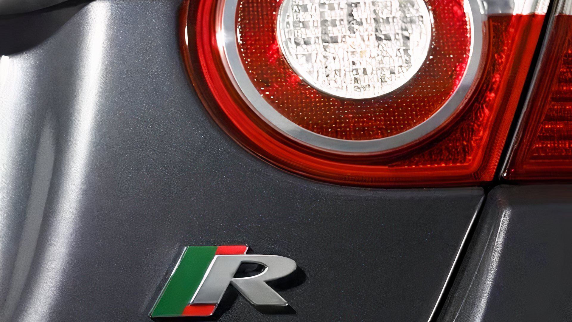 Pre-facelift Jaguar XKR displays its R badge in a close-up shot