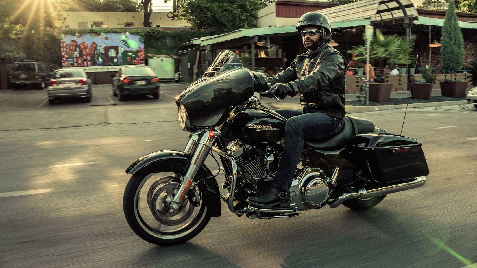 Piloto em uma Harley-Davidson Street Glide preta 2016 cruzando a cidade