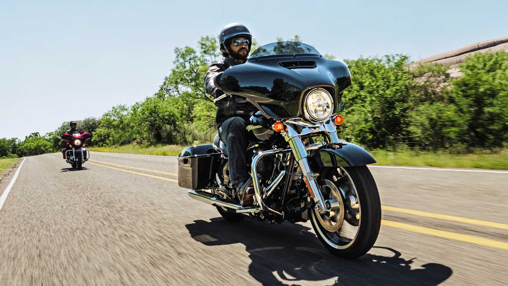 Pilotos em Harley-Davidson Street Glides 2016 navegando na rodovia