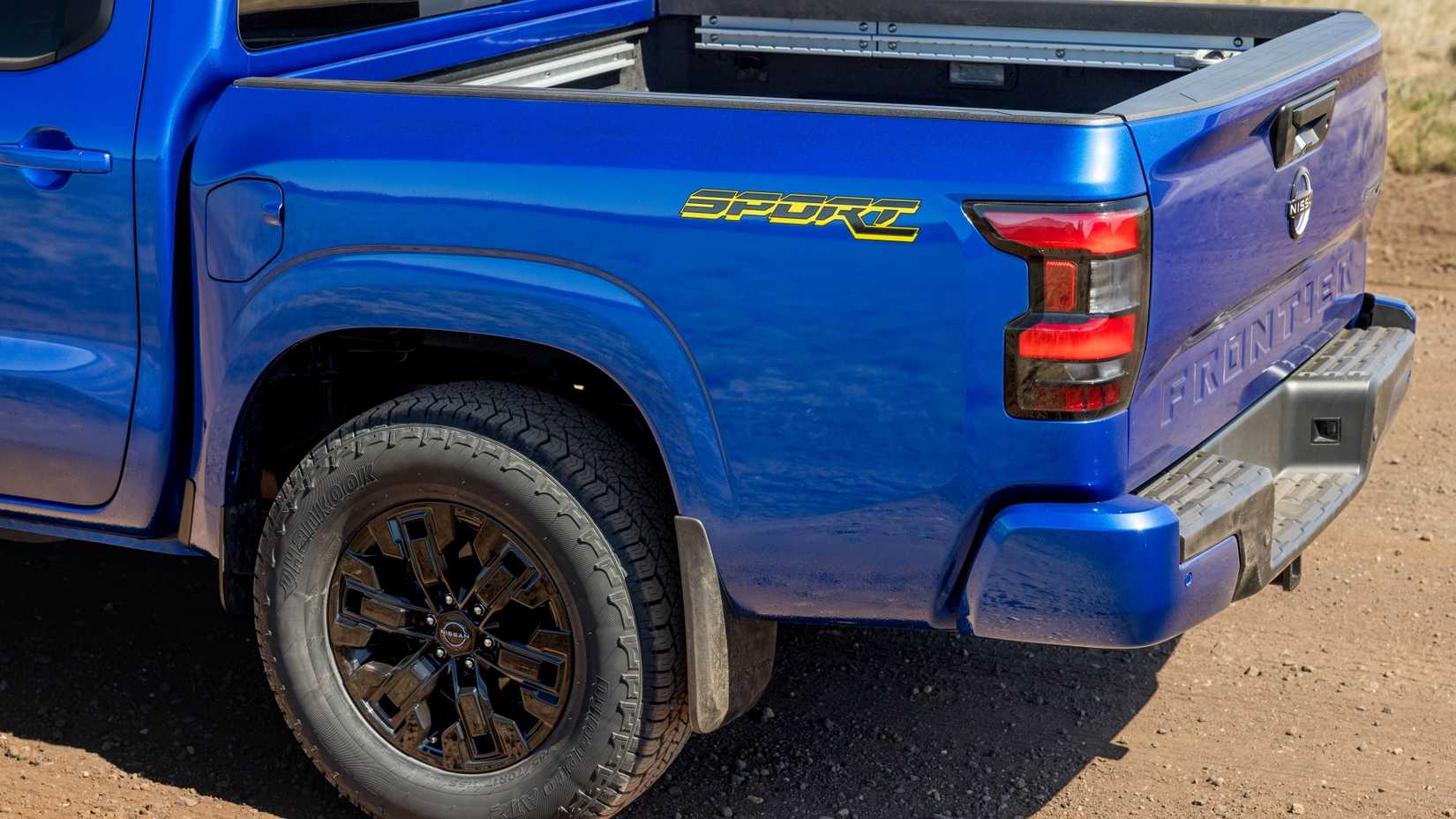 Close 3/4 traseiro de um Nissan Frontier SV Sport Edition 2027 estacionado fora de estrada