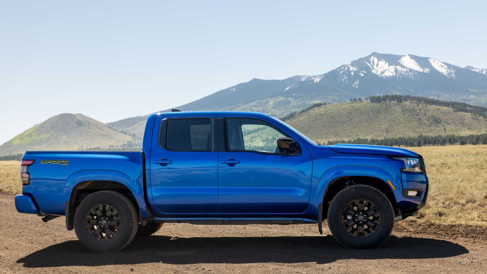 Fotografia lateral de um Nissan Frontier SV Sport Edition 2027 estacionado fora de estrada