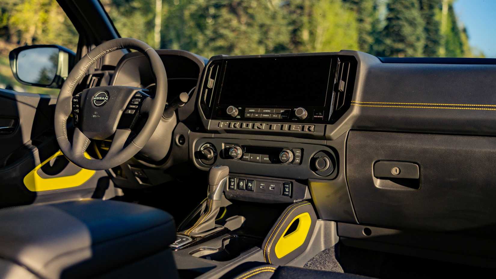 Foto do interior do Nissan Frontier SV Sport Edition 2027 mostrando a cabine dianteira e o painel