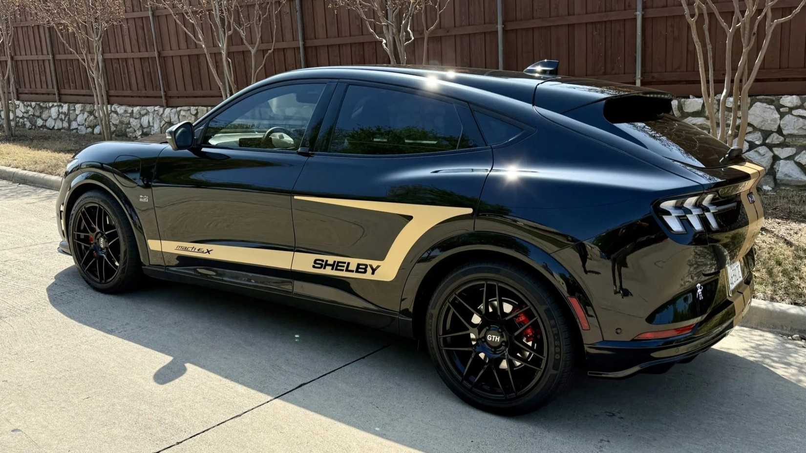 Foto traseira 3/4 de um Ford Mustang Mach-E Shelby GT-H 2023 estacionado na estrada