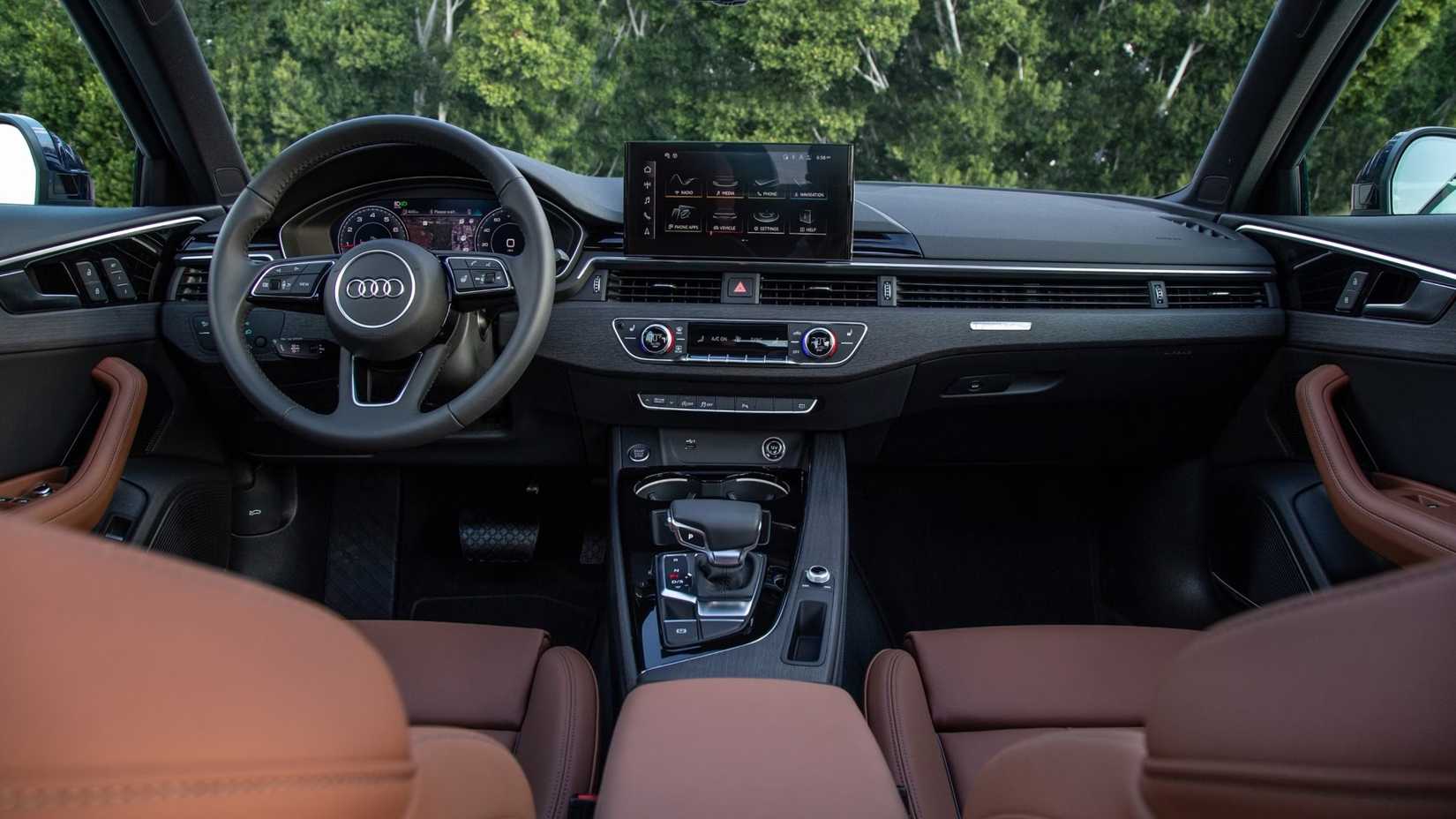Foto do interior de um Audi A4 2023 mostrando cabine dianteira e painel