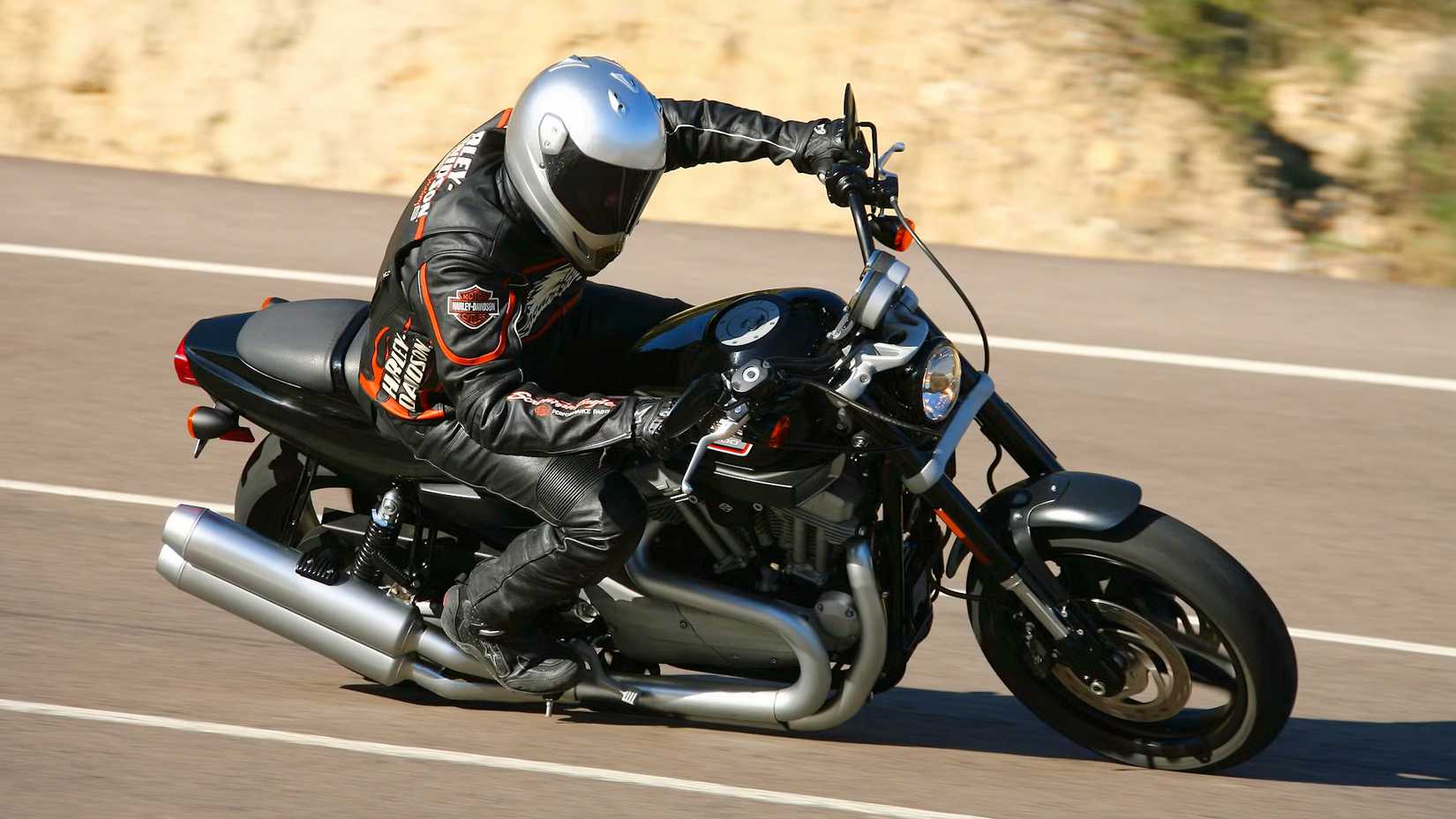 Piloto em uma Harley-Davidson XR1200 2009 inclinado em uma curva