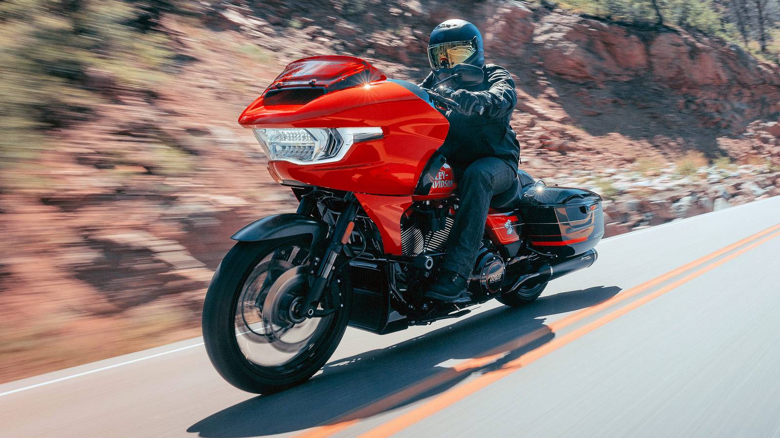 Una Harley-Davidson Road Glide in movimento lungo una strada, con silhouette familiare e dettagli moderni